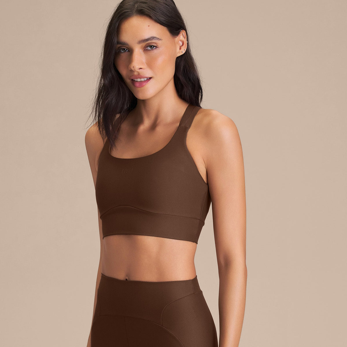 Frau in einem schokoladenfarbenen Activewear-Set